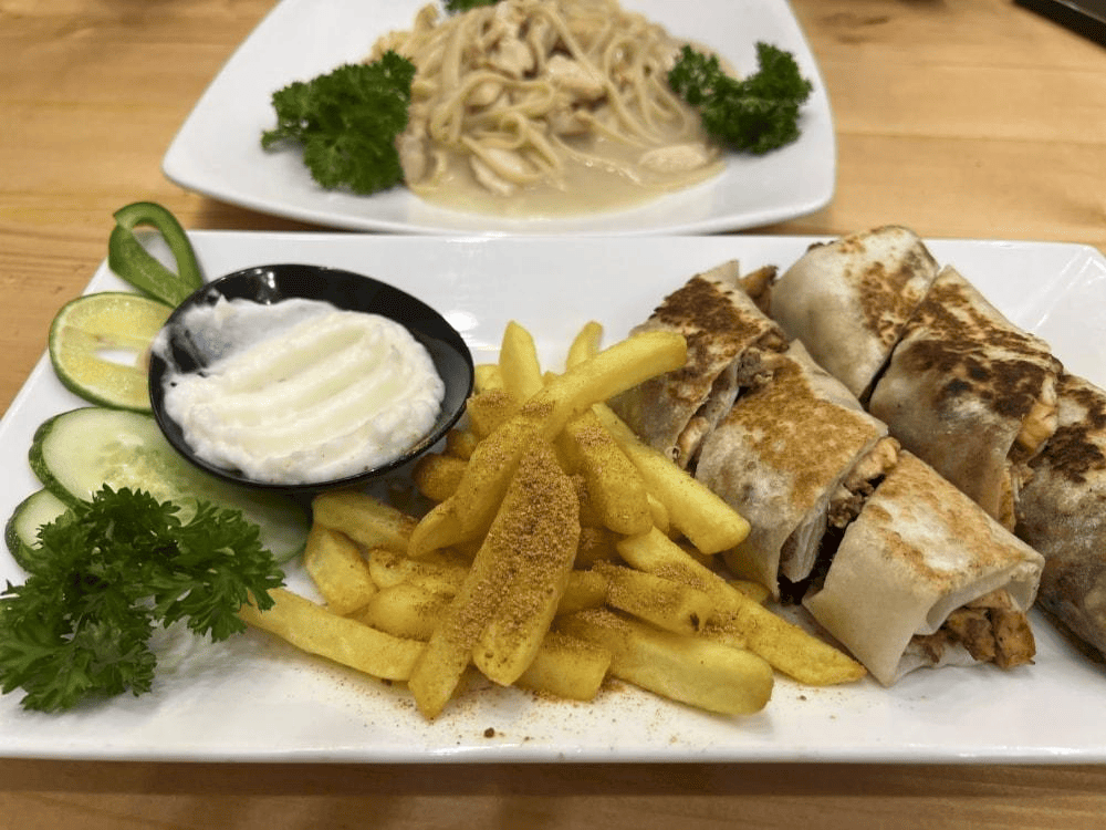 The dish offers a delightful combination of warm, grilled bread, flavorful meat, and crispy fries, all enhanced by a creamy accompaniment (Source: Internet)